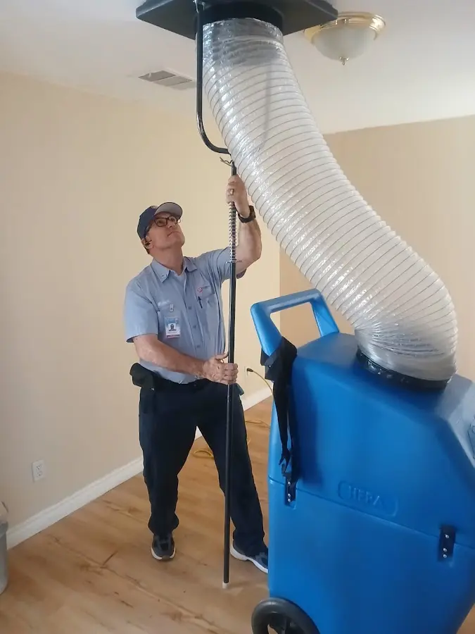 Furnace Tune-Up technician using HEPA equipment in Bryan